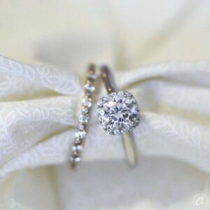 An engagement ring with a cushion-cut stone delicately set within a fine fabric to hold it in place