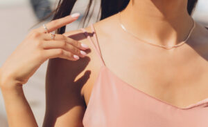 A young woman wearing a fine necklace and rings.