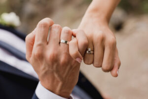 Newlywed couple's hands with wedding rings.