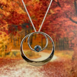 A silver necklace featuring a central blue stone.