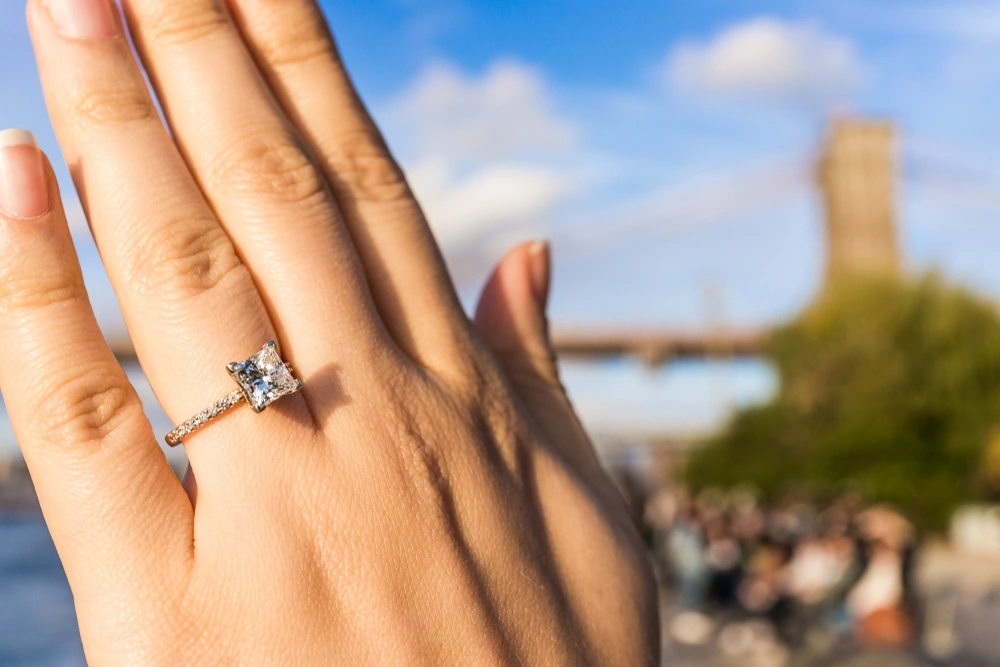 Cushion cut diamond engagement ring nestled in a box, adorned with lavender sprigs.
